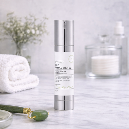 Skincare bottle on a marble surface with a white towel and decorative items in the background
